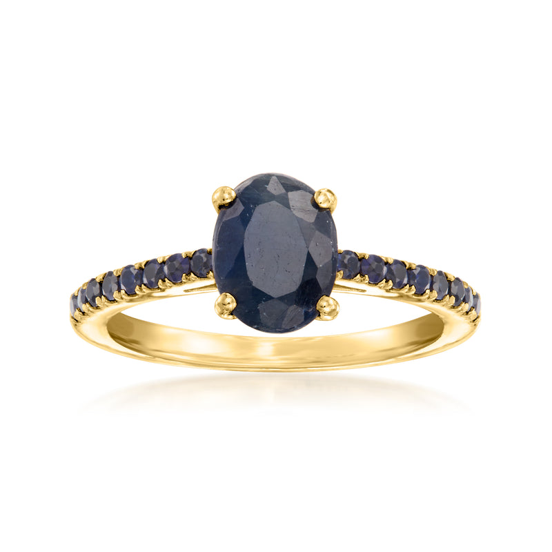 Sapphire birthstone ring with oval dark-blue center stone, gold band, blue side stones