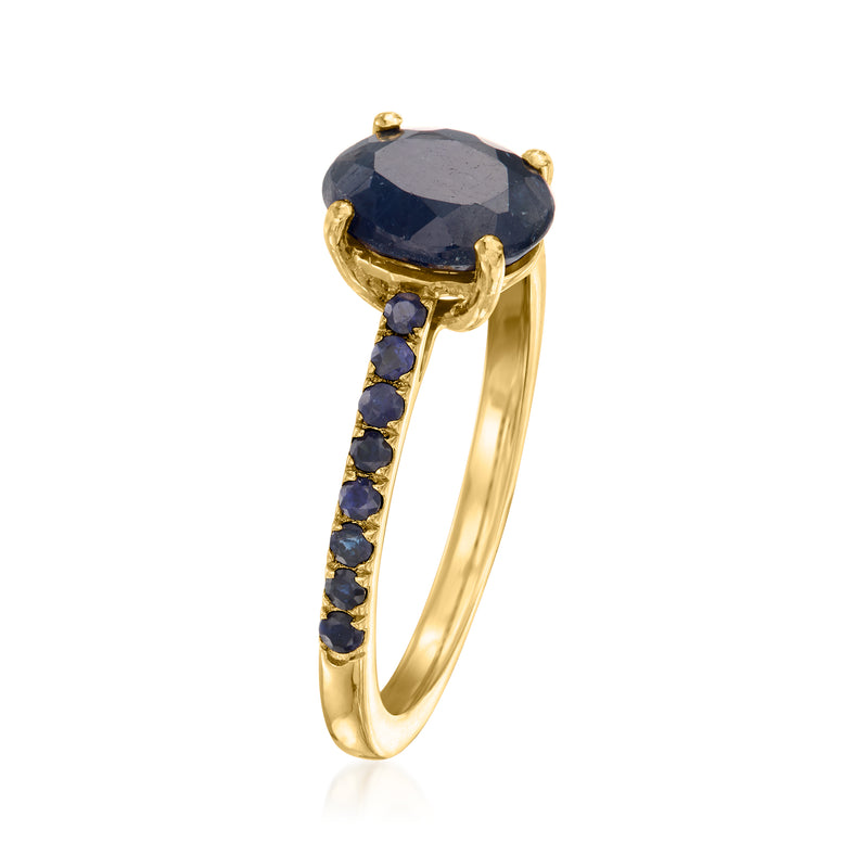 Sapphire birthstone ring with oval dark-blue gemstone in gold, blue side channel stones