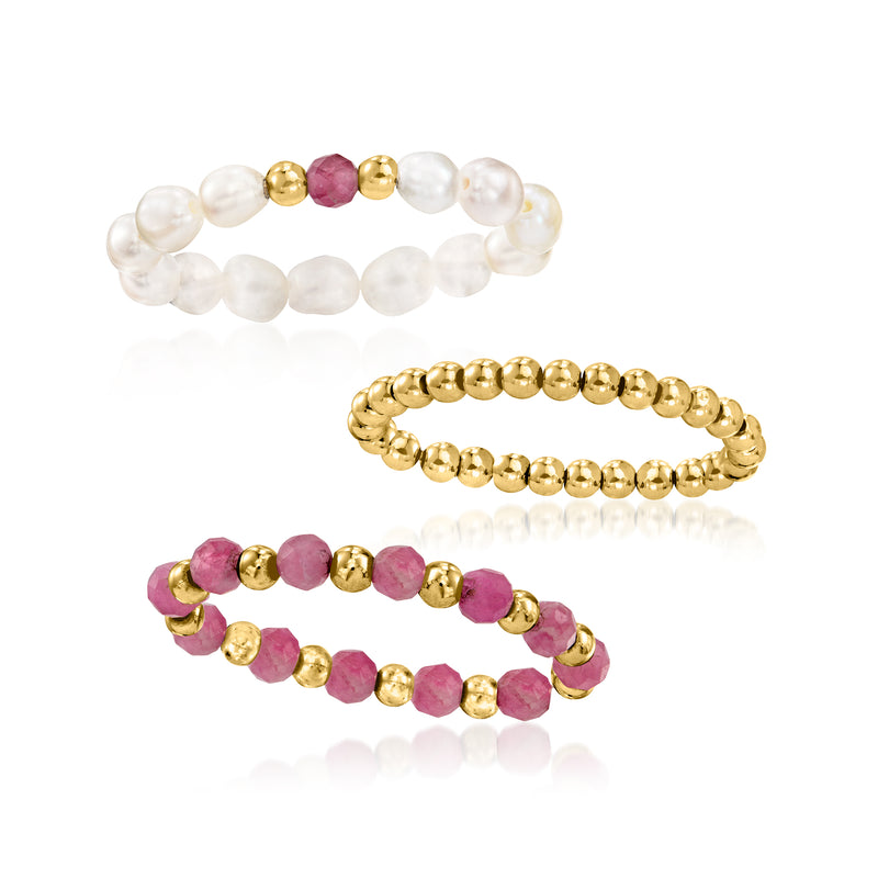 Three stretch rings, featuring white pearl and pink stone rows with yellow gold accents