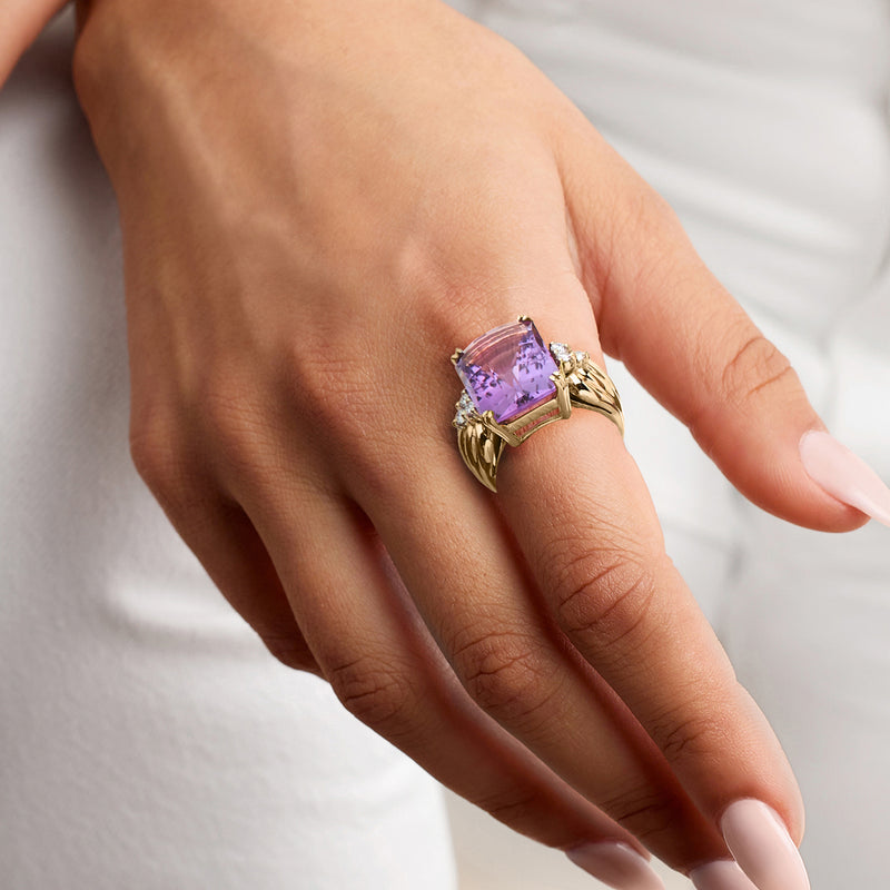 Amethyst and diamond ring on hand, cushion-cut purple center in yellow gold setting