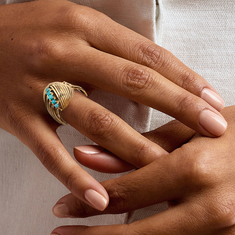 Turquoise knot ring in 18kt yellow gold on hand, braided wire and cabochon stones