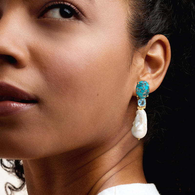 Turquoise and sky-blue drop earrings with gold-tone settings and white baroque pearl on ear