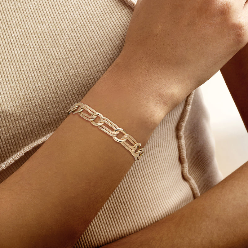Yellow gold-plated alternating oval and round-link bracelet worn on wrist