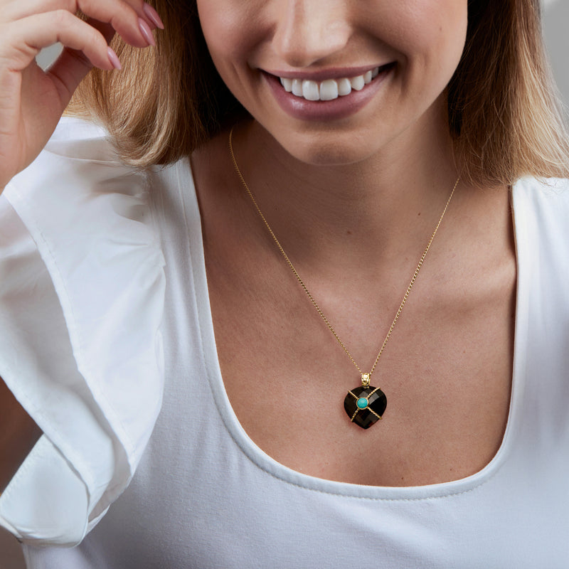 Gold chain pendant necklace with heart-shaped smoky quartz and turquoise cabochon on neckline