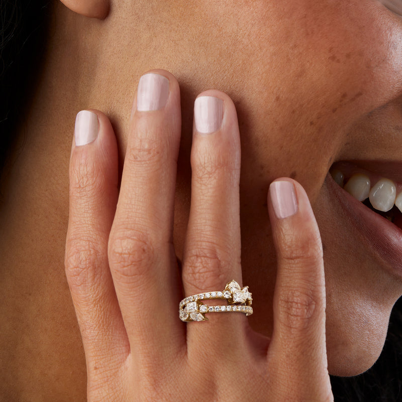 Diamond two-row ring in yellow gold with small multi-shaped stones, worn on hand