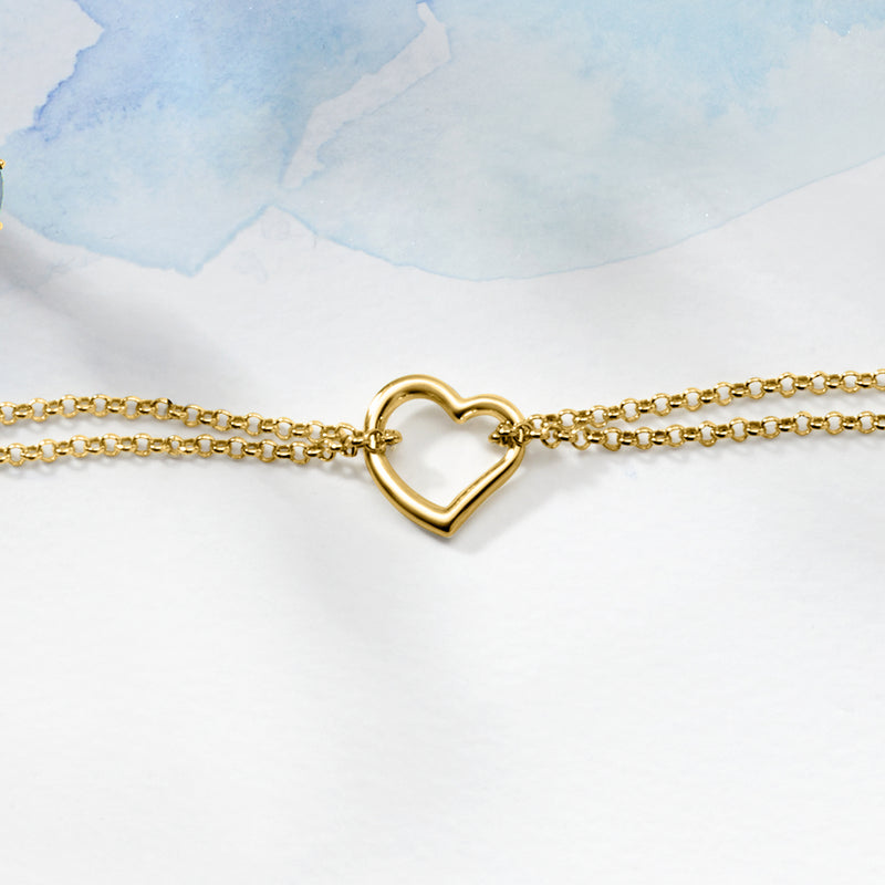 14kt yellow gold two-strand anklet close-up with heart pendant centerpiece.