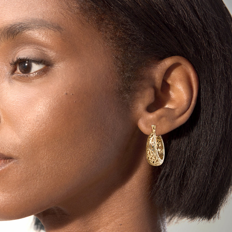 Yellow gold-plated scrollwork hoop earrings on ear, medium round filigree hoops