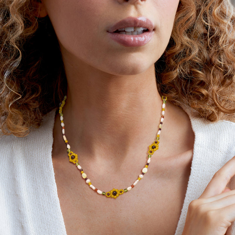 Sunflower bead necklace on model with white, yellow, and orange bead accents