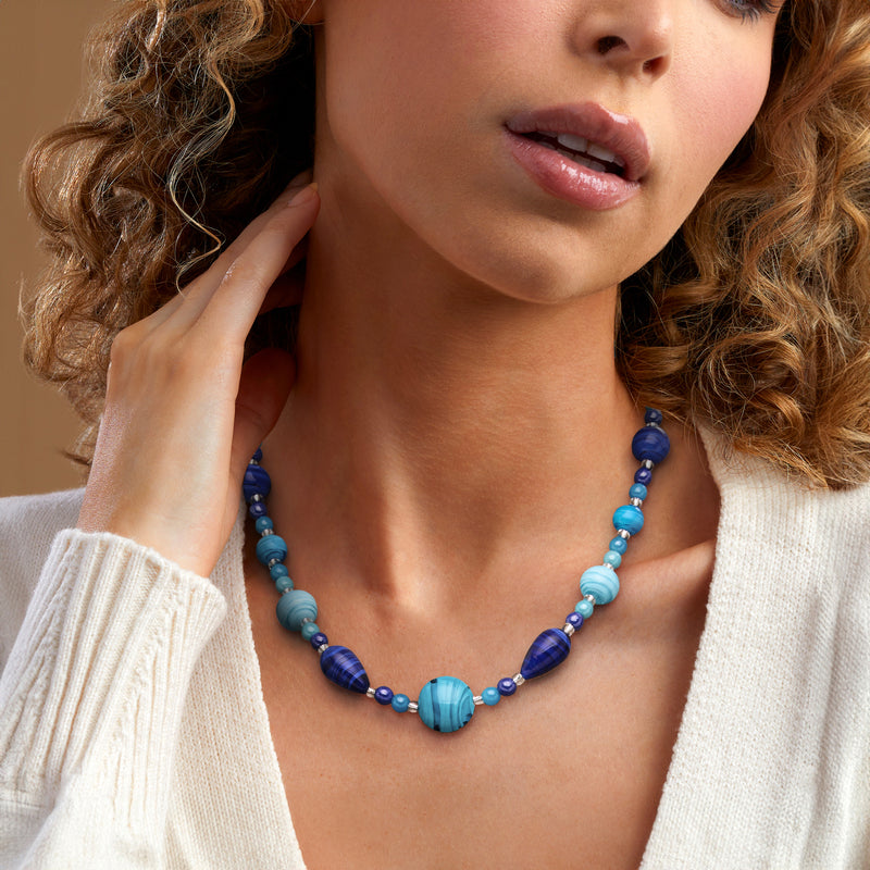 Blue Murano glass bead necklace on model with sterling silver chain at neckline