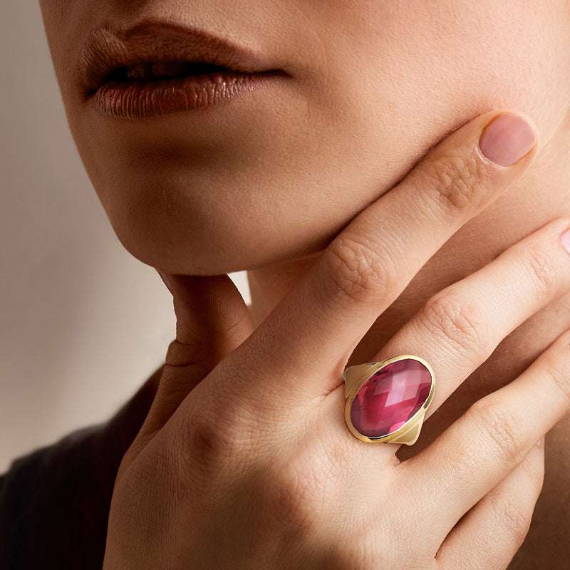 Yellow gold-plated ring with oval pink simulated tourmaline on hand