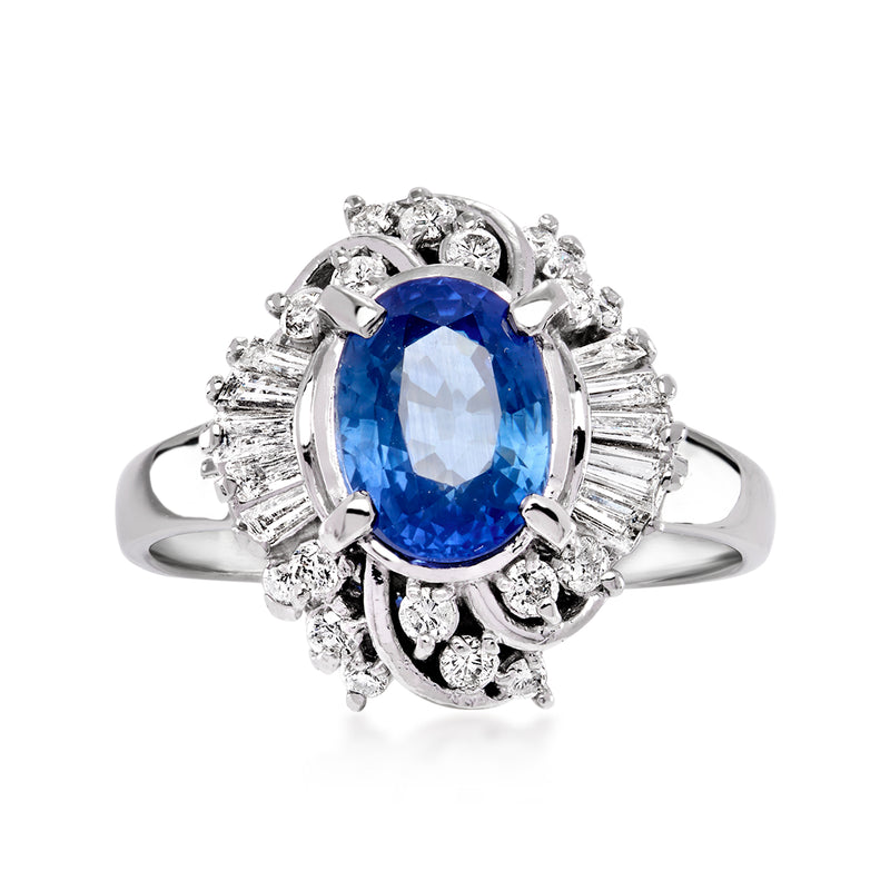Platinum sapphire and diamond halo ring with oval blue center stone and clustered side stones