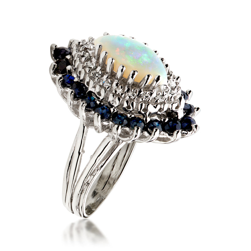 14kt white gold side-view ring with teardrop opal, blue sapphire accents, and diamond halo