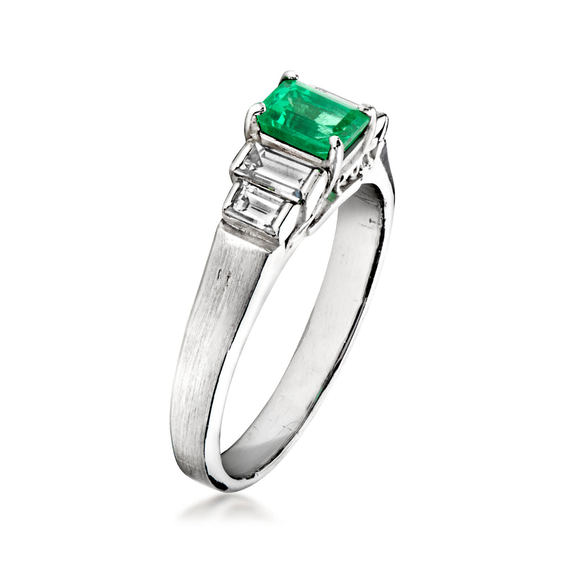 Platinum emerald-cut green stone ring with baguette diamond shoulders, side view
