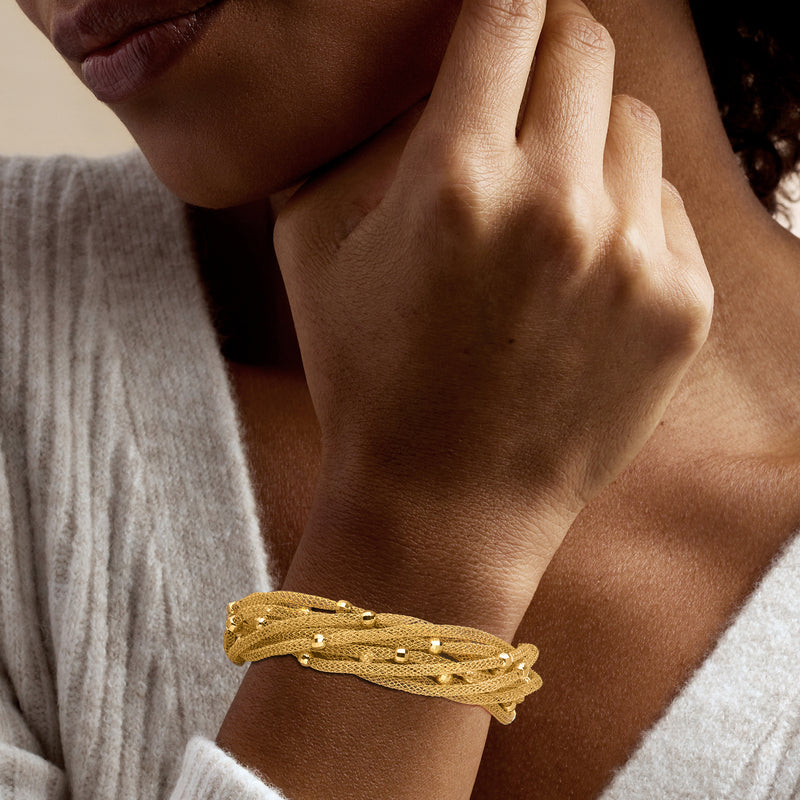 Gold beaded mesh multi-strand bracelet on wrist with small square accents