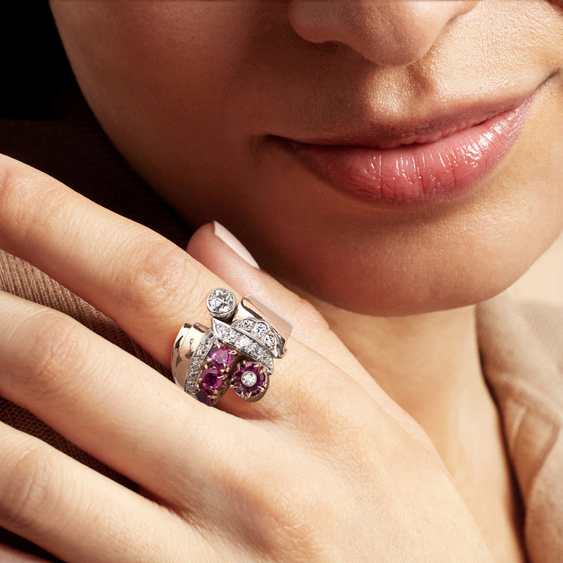 Ruby and diamond flower ring on finger with rose gold and platinum settings