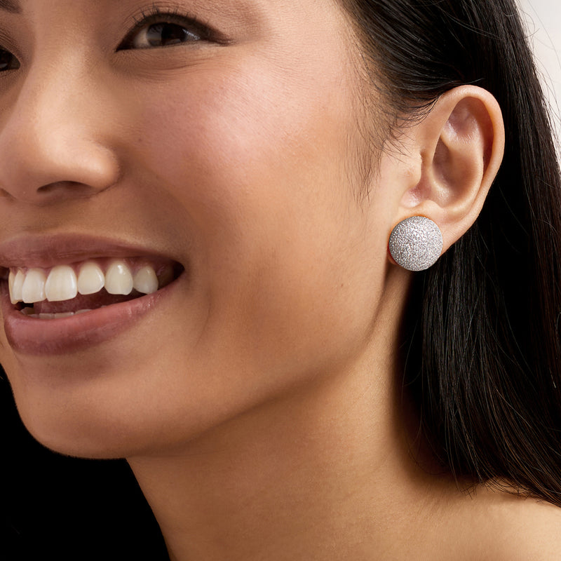 Round diamond button stud earrings on ear, 14kt white gold with sparkling pave
