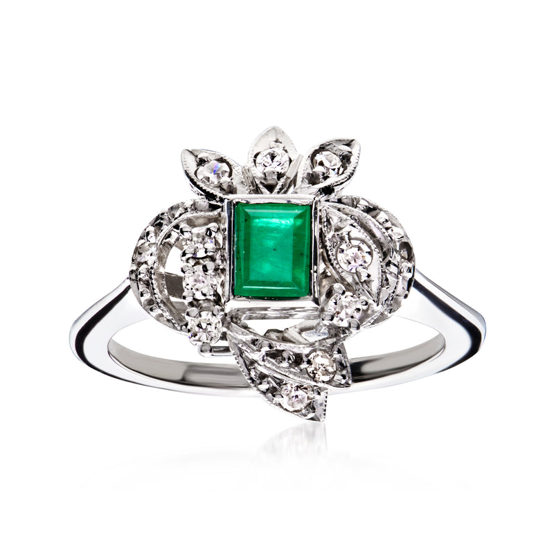 Emerald-cut green gemstone ring in silver-toned setting with diamond cluster halo