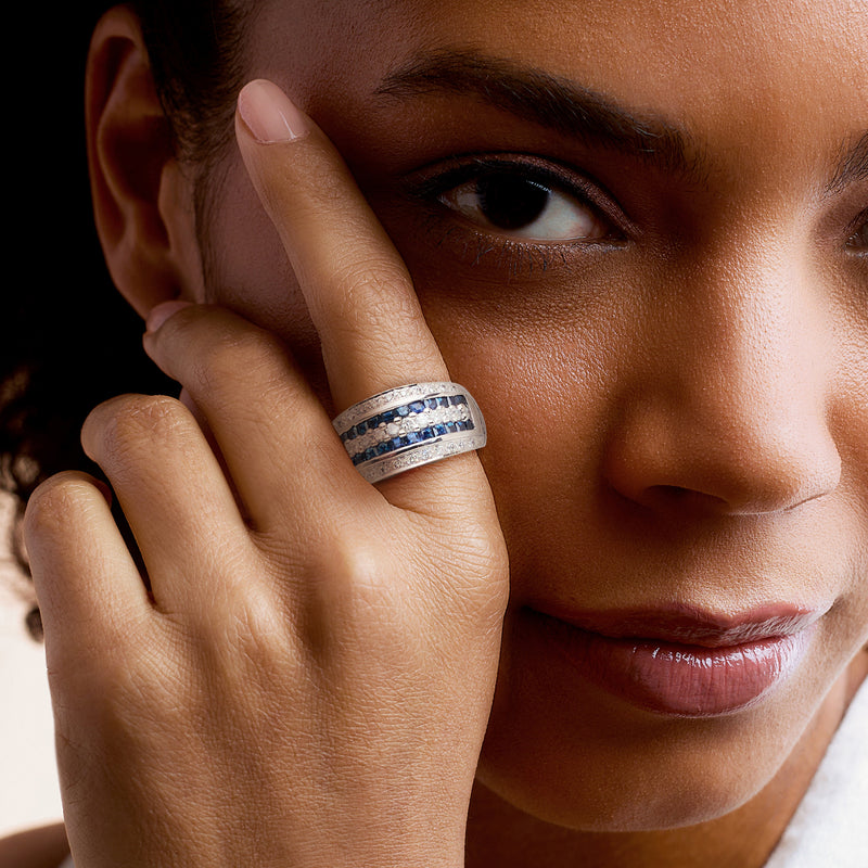 White gold sapphire and diamond ring on finger, close-up band and stones