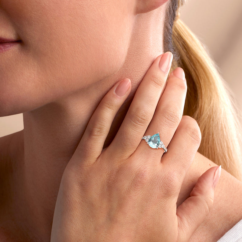 Aquamarine diamond ring on hand, oval light-blue center stone in platinum