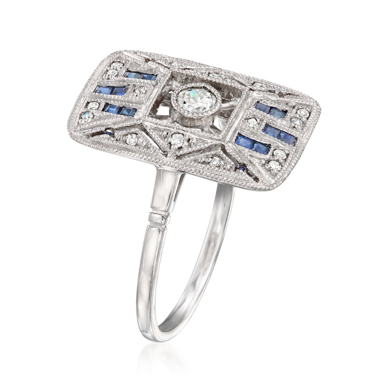 Vintage platinum ring with oval center diamond, blue sapphire accents, and openwork bezel