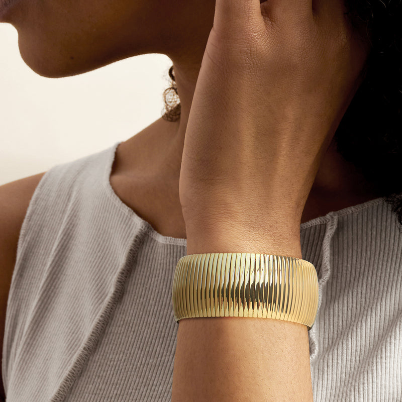 Cleopatra cuff bracelet, yellow gold-plated ribbed band, worn on wrist