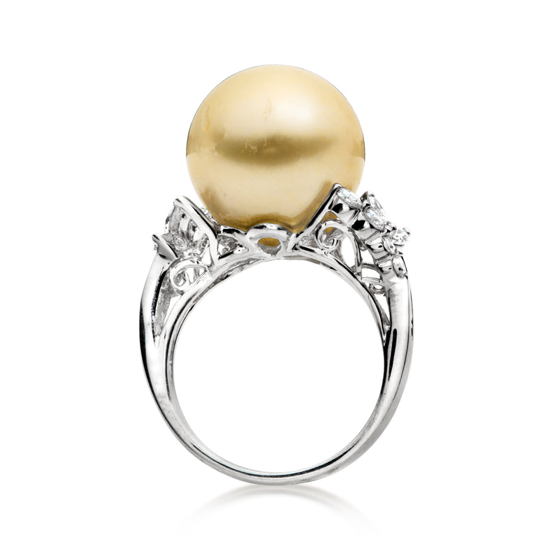 Golden pearl engagement-style ring with diamond halo setting on white gold