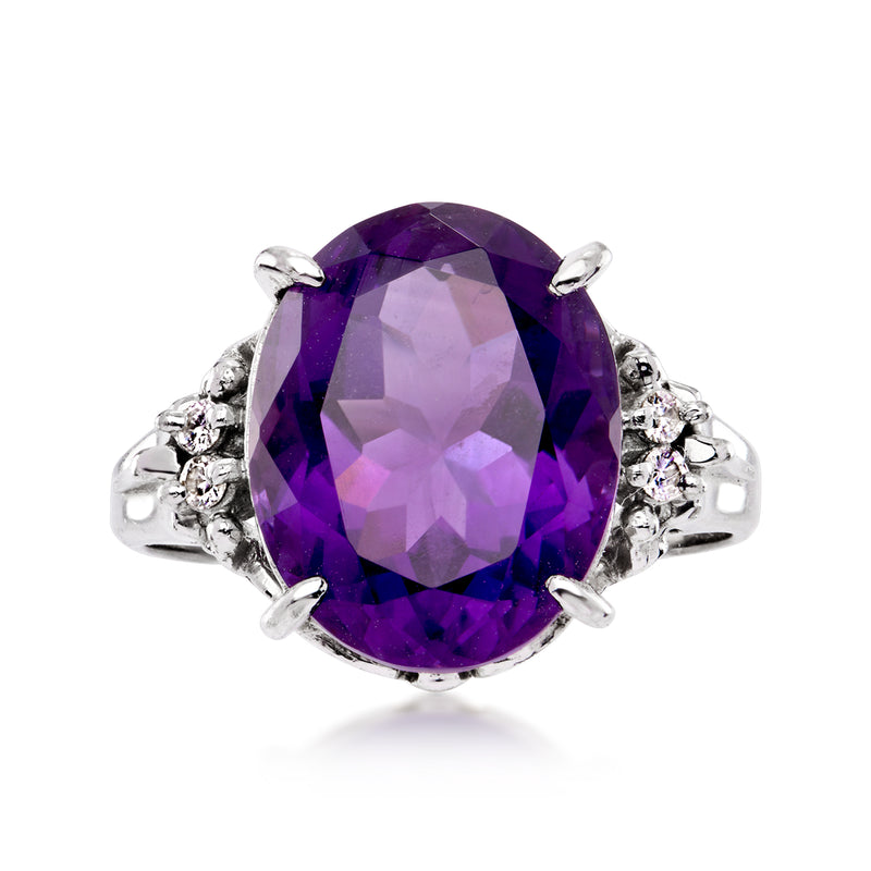 Platinum ring with oval amethyst center and small diamond side accents, prong-set
