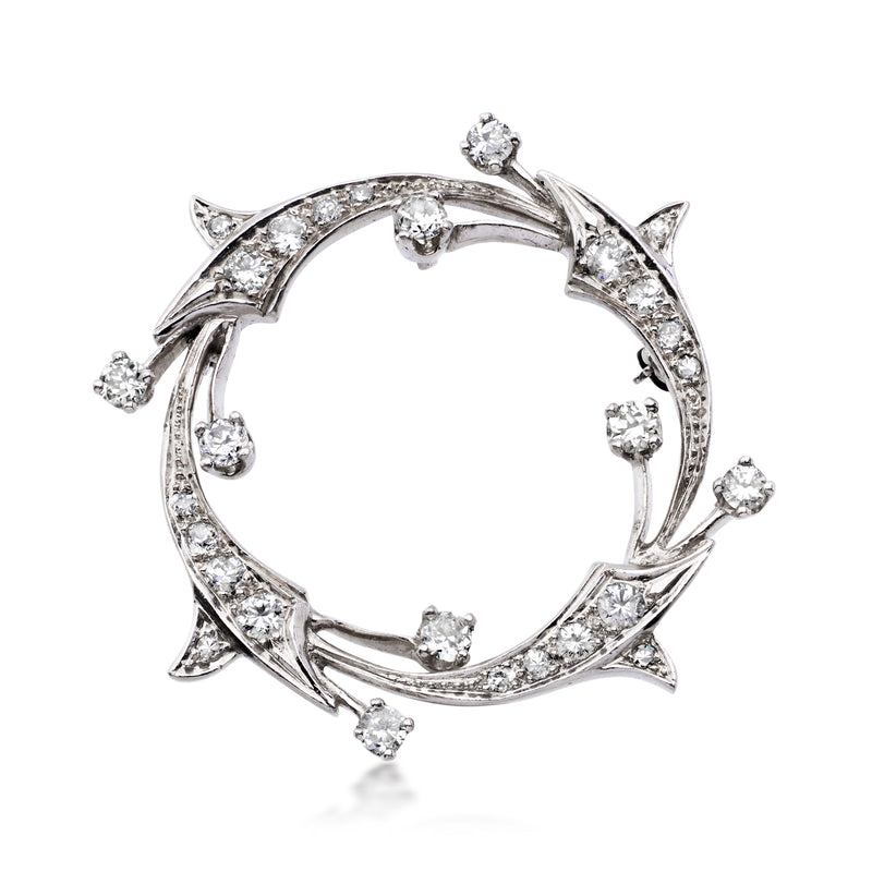 Platinum diamond circle pin with openwork ring and starburst accents, round stones