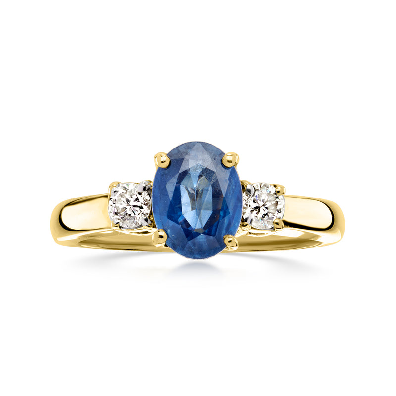 Yellow gold ring with oval blue sapphire center and two round diamond side stones