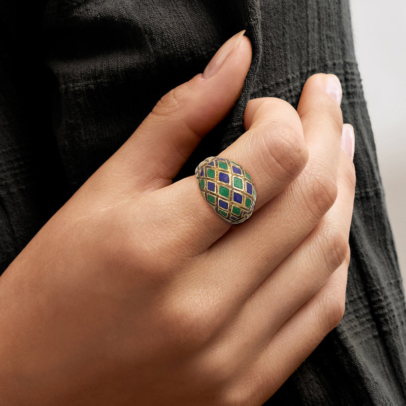 Enamel ring on finger with blue and green square lattice design, gold band