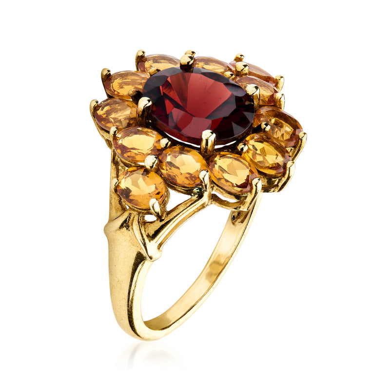 Yellow gold oval ring with dark red center stone and round yellow side stones