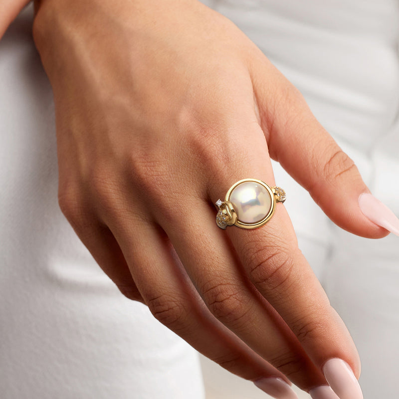 18kt yellow gold ring on hand with mabe pearl top and diamond accents