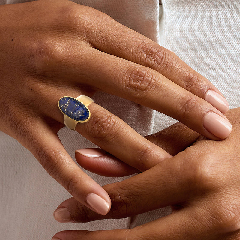 Vintage oval lapis ring in 14kt yellow gold worn on hand, blue cabochon