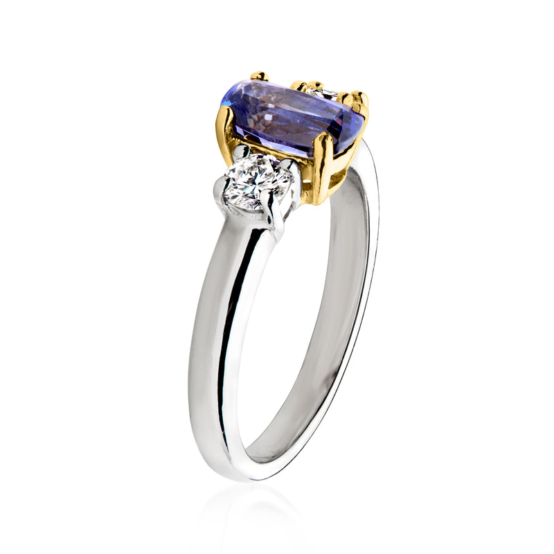 Tanzanite ring side view with oval blue center stone, diamond accents, gold bezel on platinum