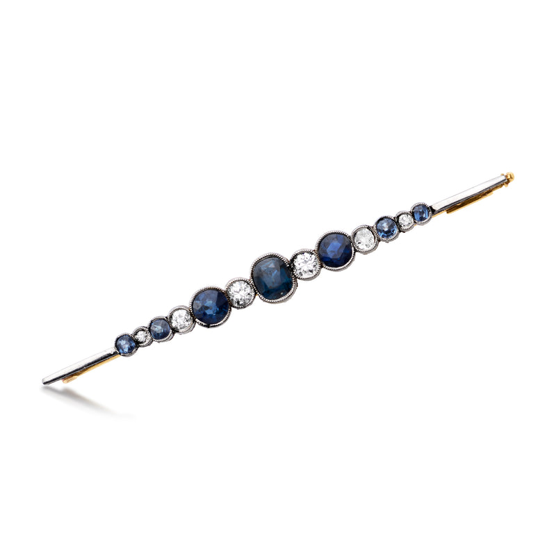 Sapphire and diamond bar pin with blue round stones and small white accents, metal bar