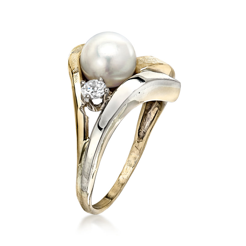 Two-tone gold ring with white pearl center and round diamond cluster detail