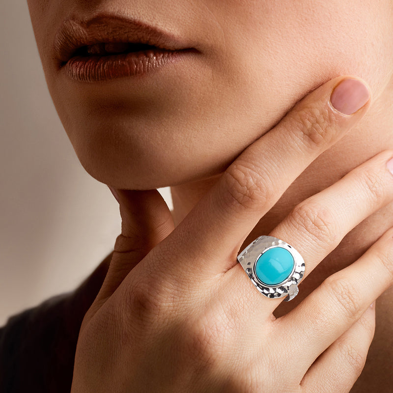 Sterling silver-plated wrap ring with round turquoise cabochon on finger
