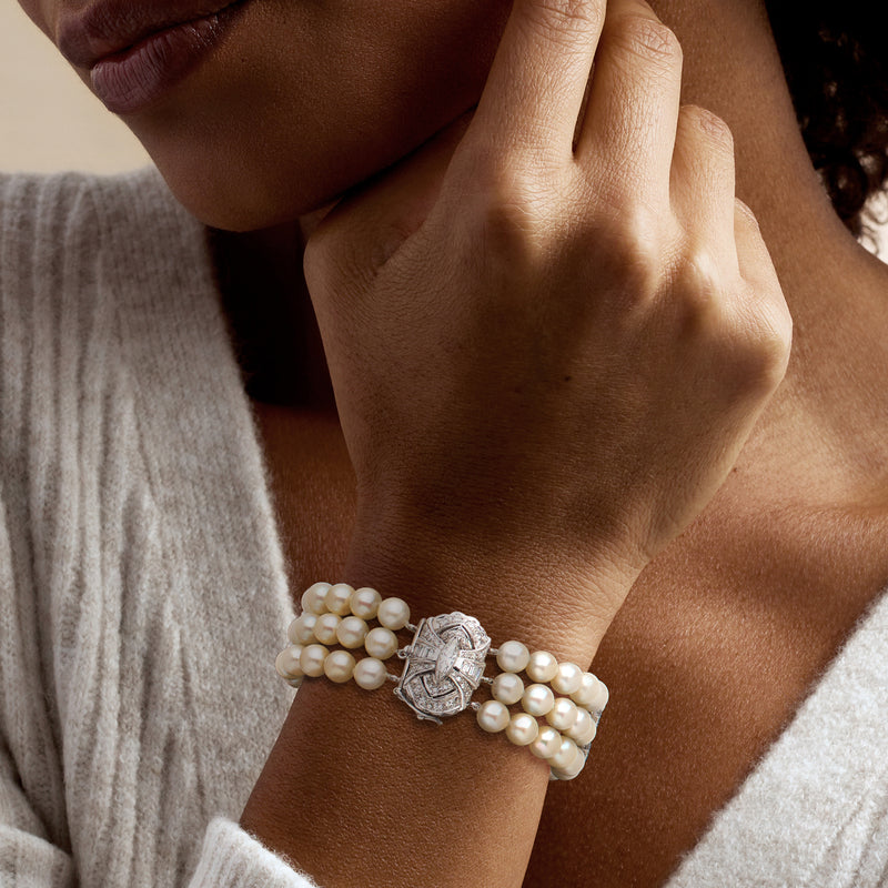 Pearl bracelet with diamond clasp worn on wrist, three-row style