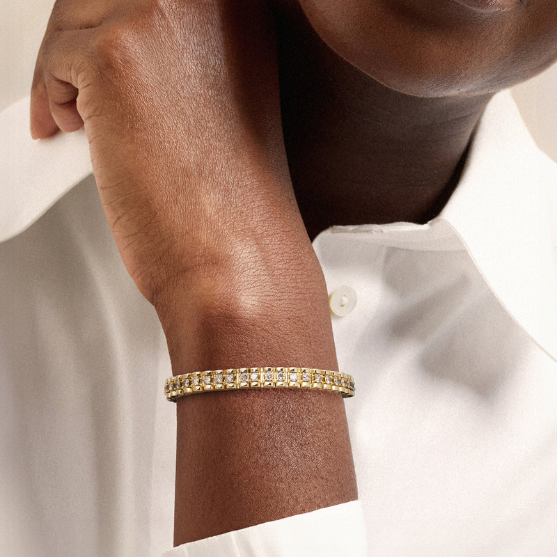 Yellow gold diamond tennis bracelet on wrist with sparkling rectangular stones