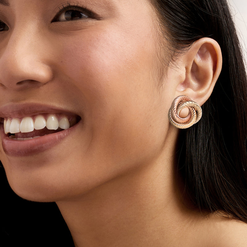 Tri-color knot hoop earrings shown being worn on ear
