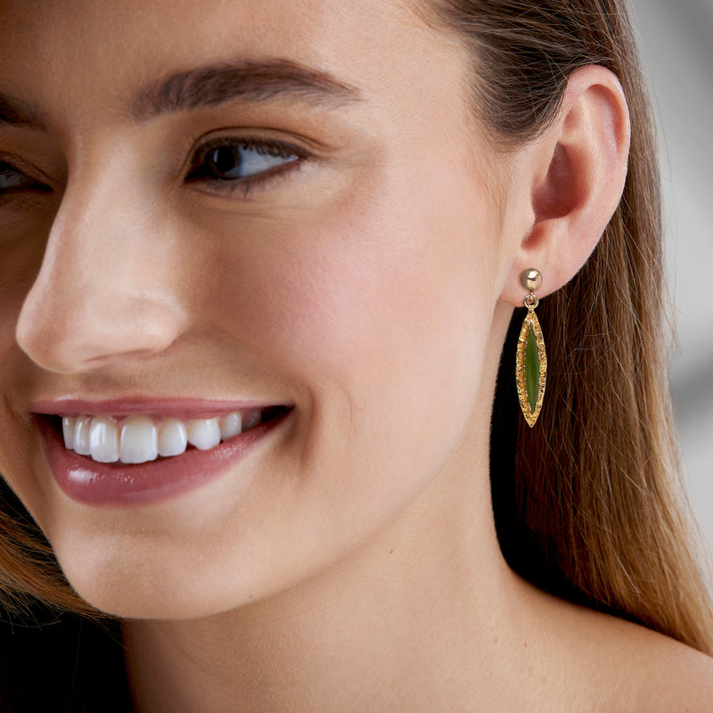 Marquise jade drop earrings worn, green marquise stones in 10kt yellow gold settings.