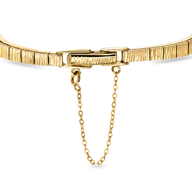 Two-tone gold diamond bracelet with decorative center and dangling chain