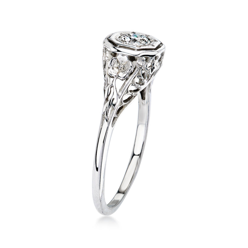 White gold vintage diamond ring with raised prongs and filigree side details