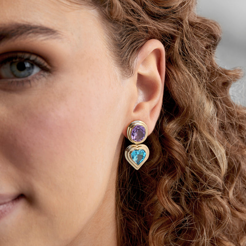 Yellow gold drop earrings with purple top and blue heart stones, side view