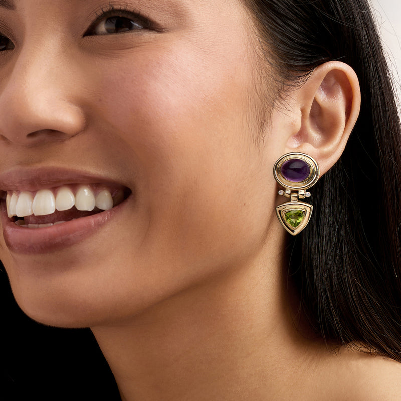 Gold drop earrings worn, round amethyst top and green peridot triangle with diamond details