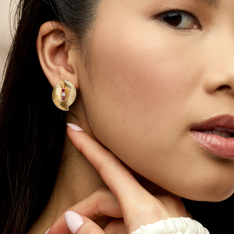 Gold fan clip earrings with ruby center and white diamond accents on model