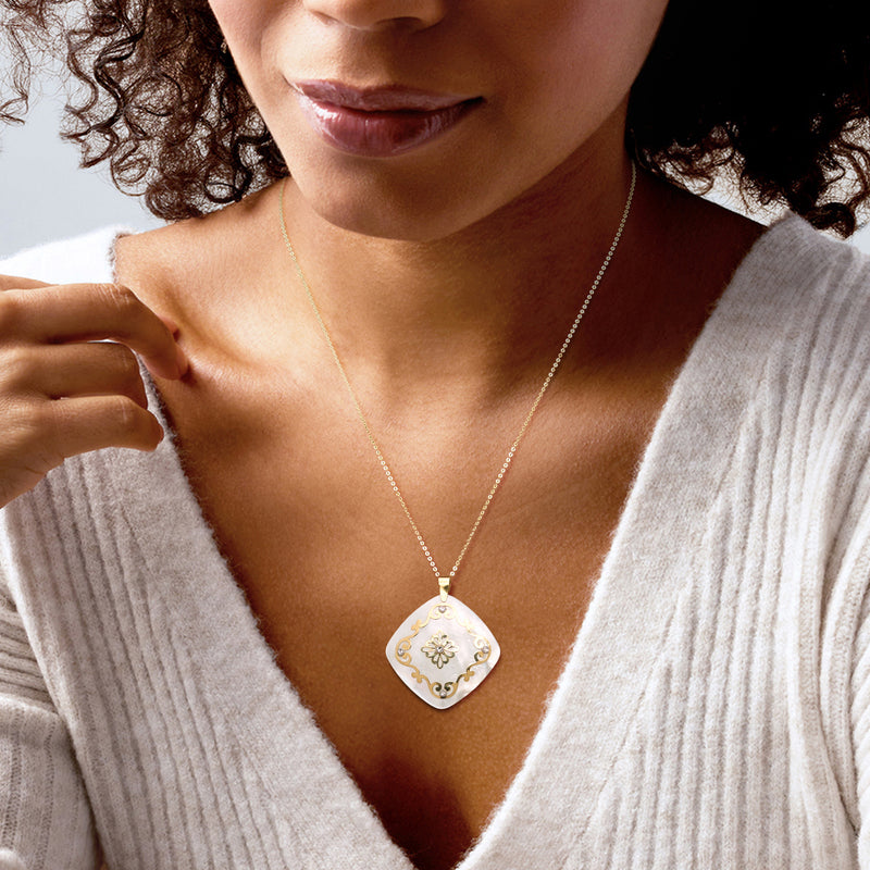 Two-tone gold pendant necklace on model, mother-of-pearl teardrop pendant with floral detail