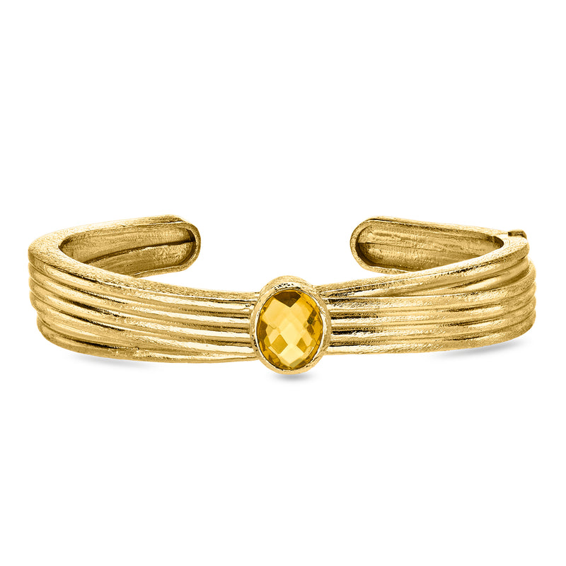 Gold-tone cuff bracelet with ribbed metal and oval gemstone centerpiece