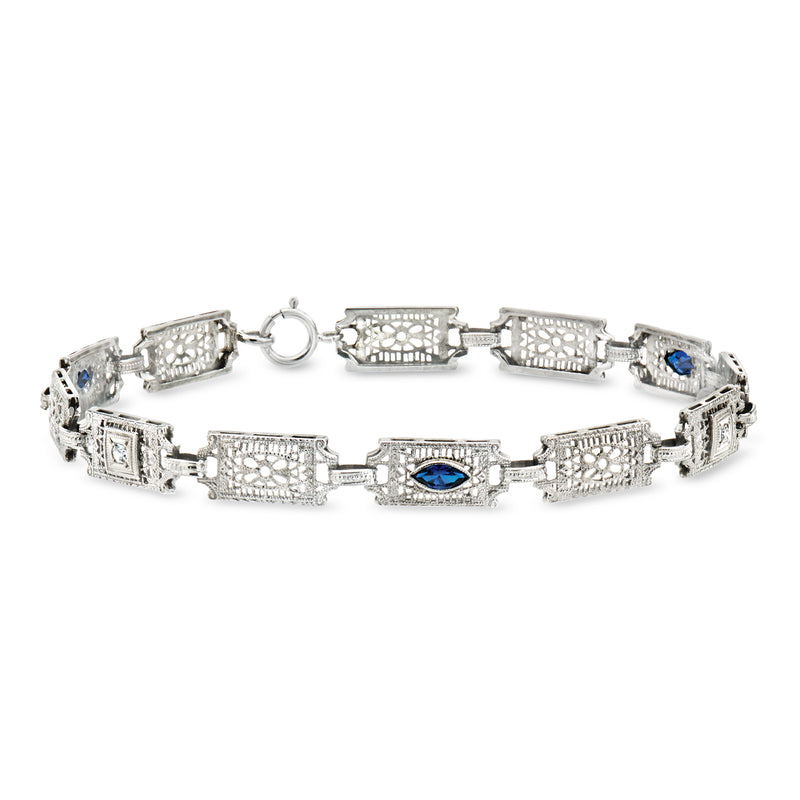 Vintage white gold bracelet with filigree links, blue center stones, and small diamond accents