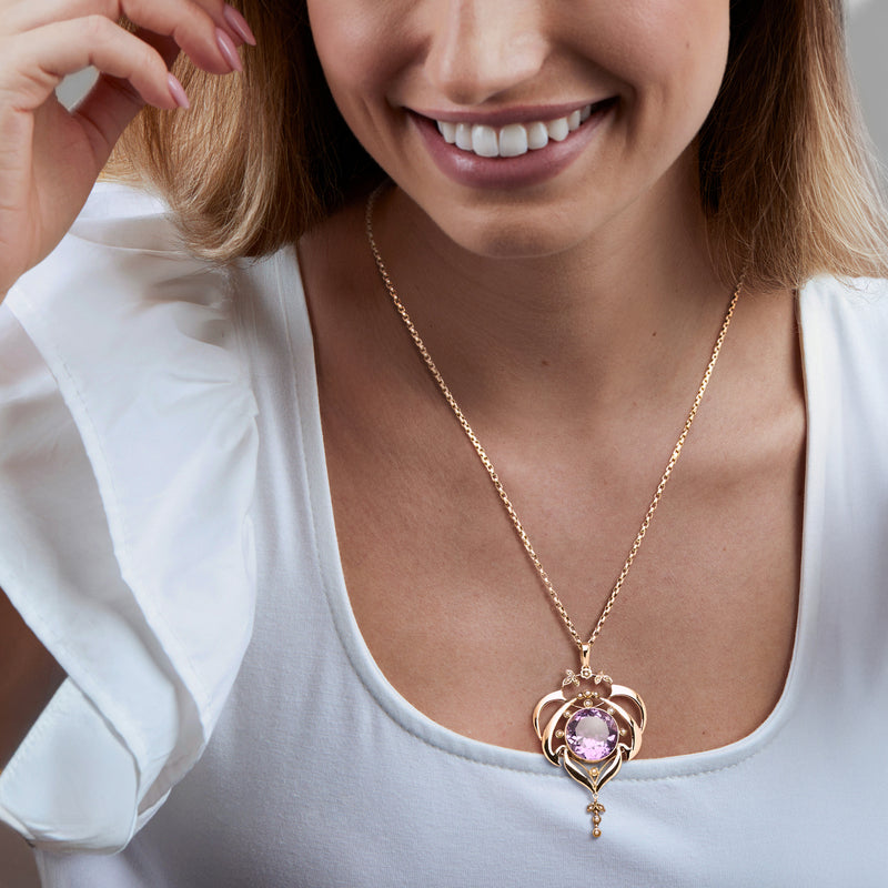 Amethyst pendant necklace on a gold chain with seed pearl details.